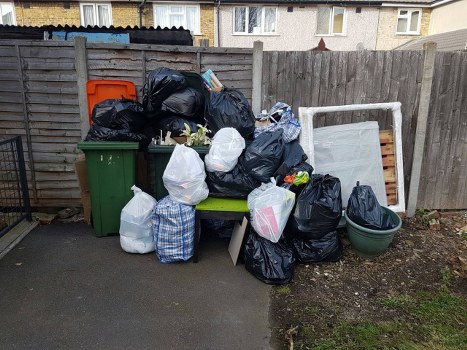 Waste collection team handling household rubbish in a London residential area